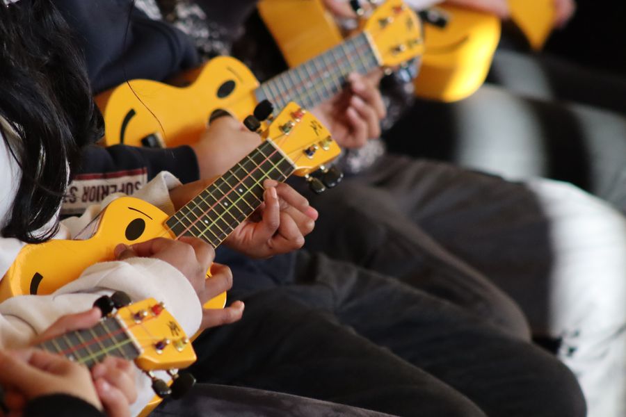 Kinder musizieren gemeinsam auf Ukulelen